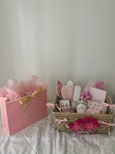 two baskets filled with items sitting on top of a white bed next to each other