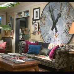 a living room filled with furniture and a large clock mounted to the wall above it