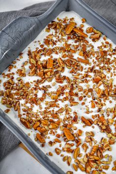 a pan filled with yogurt and nuts on top of a table