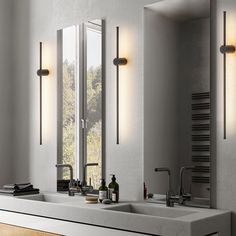 a bathroom with two sinks and three lights on the wall next to eachother