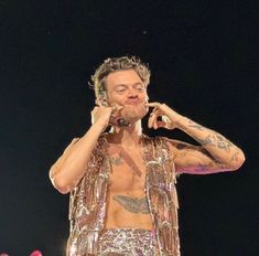 a man with tattoos on his chest holding a microphone