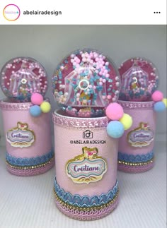 three pink and blue tin canisters with pom poms on the top