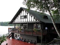 people are standing on the deck of a lake house