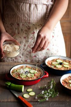 a woman pouring water into a bowl filled with food on top of a wooden table