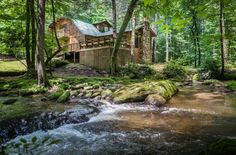 a small cabin in the woods near a stream