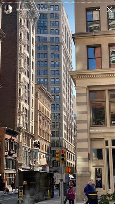 a city street filled with tall buildings next to traffic lights and people walking on the sidewalk