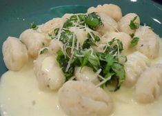 a green plate topped with dumplings covered in cheese