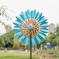 a blue and gold sunflower wind spinner sitting on top of a metal pole