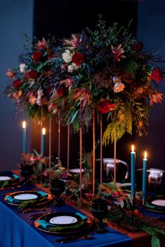 the table is set with candles, plates and flowers