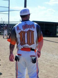 a baseball player standing in the dirt with his hands on his hips and wearing gloves