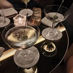 two martini glasses sitting on top of a table