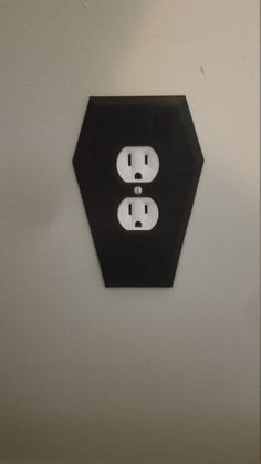 two black and white outlets are attached to the wall