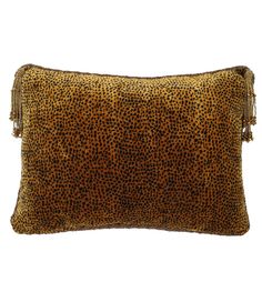 a leopard print pillow with tassels on the front and back ends, in gold