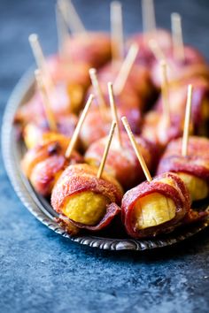 bacon wrapped bananas on a plate with toothpicks