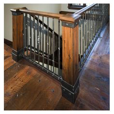 an iron and wood banister in a house with hardwood floors, railings and windows