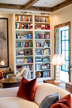 a living room filled with furniture and lots of books