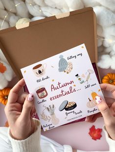 someone holding up an autumn essentials card