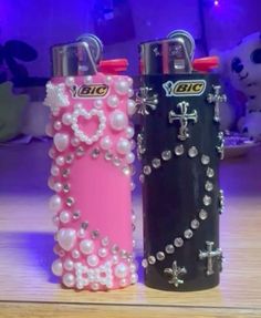 two lighters with pearls and crosses on them