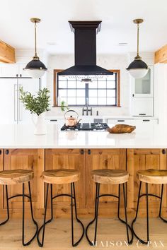 three stools sit in front of the kitchen island