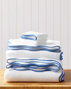 three folded towels stacked on top of each other in front of a white and blue striped wall