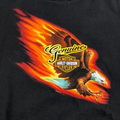 a black shirt with an eagle and flame design on it's chest is shown