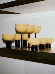 there are many yellow bowls on the shelf