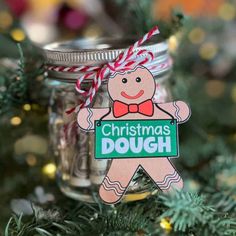 a christmas ornament hanging from a tree with a mason jar filled with candy canes