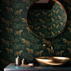 a bathroom sink with a mirror above it and a leopard wallpaper on the wall