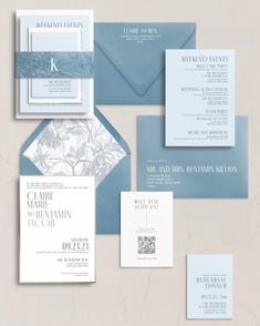 an assortment of wedding stationery and envelopes on a beige background with blue accents