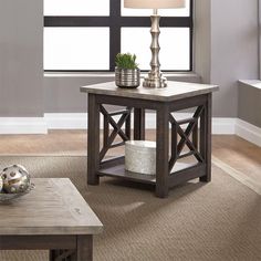 a living room with a coffee table and two end tables in front of a window