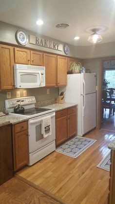 a kitchen with wooden floors and white appliances