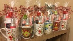 christmas mugs are lined up on a table with candy canes wrapped around them