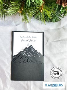 a black and white wedding card with mountains on it