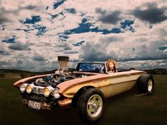 a woman sitting in the back of a car with an engine on it's hood