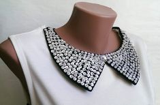 a white dress with a black and silver necklace on it