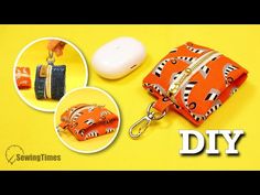 an orange and black purse sitting on top of a yellow table next to a white mouse