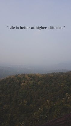 a view of trees and hills with the words life is better at higher altitudes