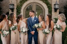 a group of people standing next to each other in front of a building with flowers