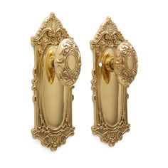 two golden door knobs with ornate designs on the front and back doors, one is open