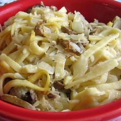 a red bowl filled with pasta and mushrooms