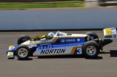 a man driving a race car around a track