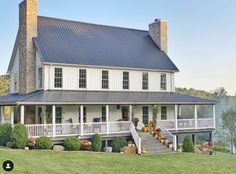 a large white house sitting on top of a lush green field