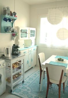 a kitchen filled with appliances and furniture next to a dining room table in front of a window