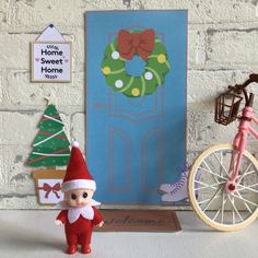 there is a toy elf next to a door and a bicycle on the shelf in front of it