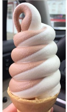 an ice cream cone with pink and white icing