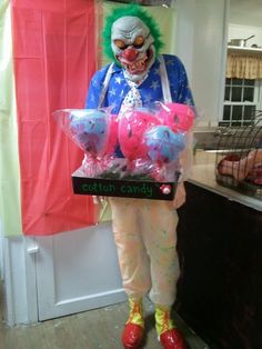 a creepy clown holding some candy in his hands