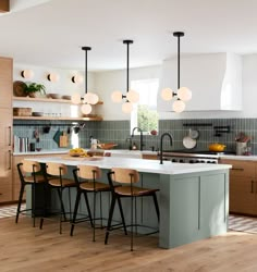 a kitchen with an island and several chairs around it, in front of a window