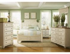 a bedroom with green walls and white furniture