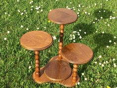 three wooden tables sitting on top of a lush green field