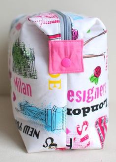 a white bag with colorful designs on the front and side, sitting on a table